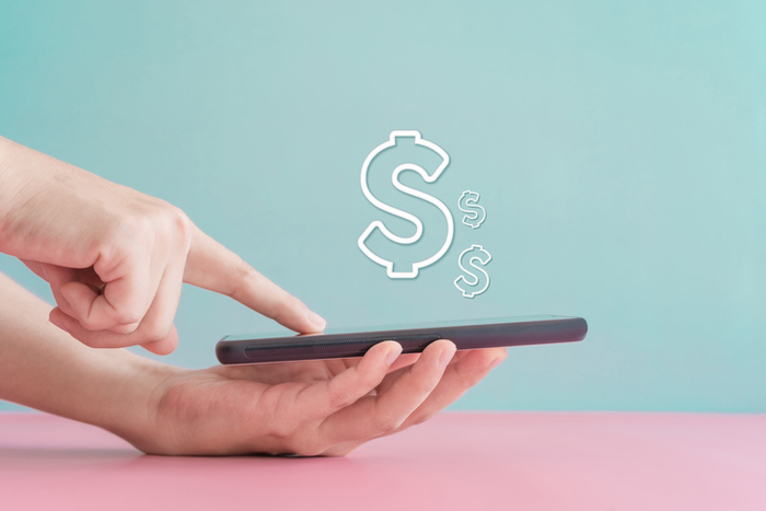  dollar sign icon floating above smartphone
