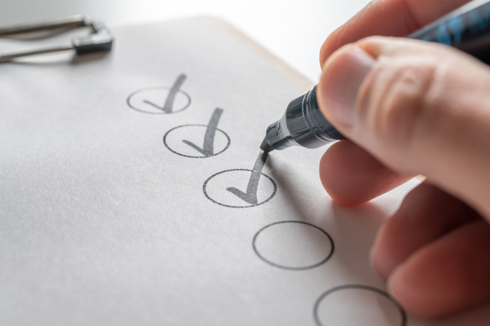 Person checking off a to-do list with a black pen