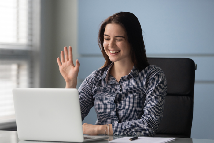 Happy young businesswoman holding video call with clients.