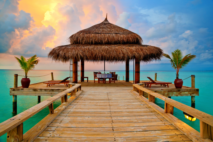 Tropical hut on water at sunset