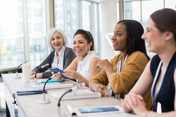 A panel of women present information