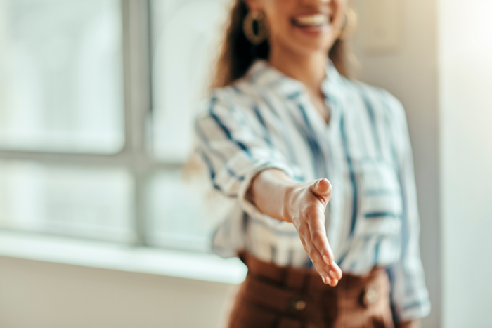 Open handshake, office and woman with welcome, kindness and smile for meeting, respect and friendly. Black woman, hr expert and hand shake for hiring, human resources or recruitment with happiness