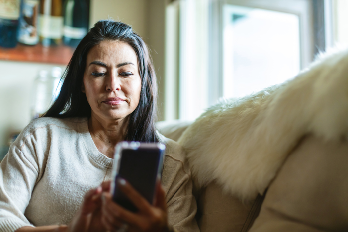 Mature Adult Female of Hispanic Ethnicity Using Smart Phone In the Home Photo Series