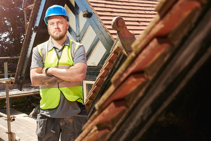 proud construction worker on roof scaffold