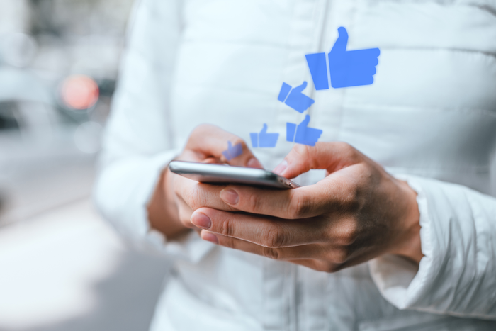 A young girl uses a smartphone gets likes on social networks.