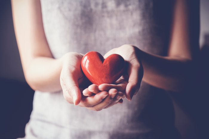 woman holding red heart, health insurance concept
