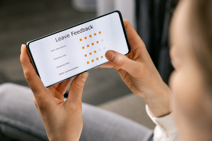 customer review - woman using phone to rate her experience about online shopping service and product quality
