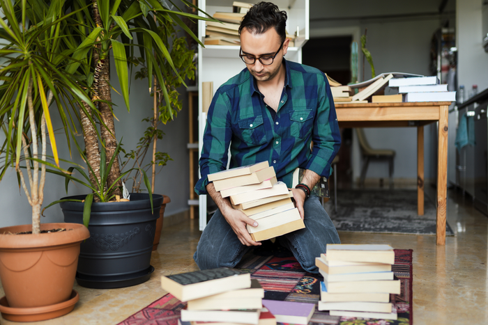 man organizing books