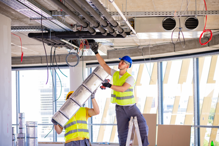 Man setting up ventilation system indoors